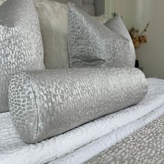 a close up of a bed with pillows on it