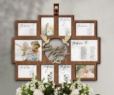 a wooden cross with pictures and flowers in front of it on a table next to a vase