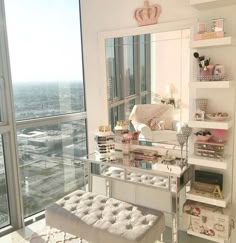 a bedroom with a large window and a white bench in front of the mirror on the wall