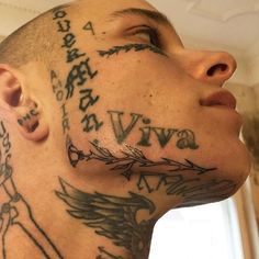 a man with tattoos on his face and neck