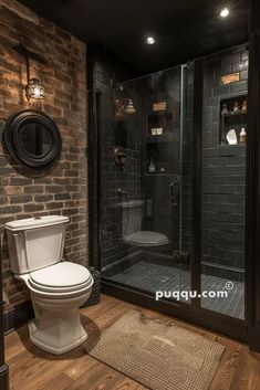 a bathroom with a toilet, shower and brick wall in the background is a wooden floor