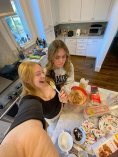 two girls are eating cereal in the kitchen