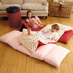 two children laying on pillows in the living room