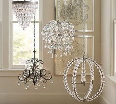 three chandeliers hanging from the ceiling in front of a window