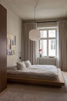 a bedroom with a bed, rugs and curtains in it's windowsill