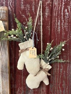 a teddy bear hanging on the side of a wooden door with a tag attached to it