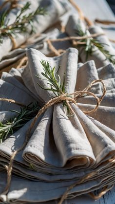 napkins tied together with twine and rosemary sprigs on top of them