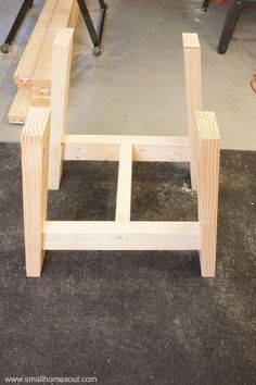 two wooden benches sitting on top of a floor next to some workbench tools