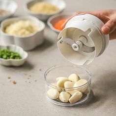 someone is adding ingredients to their food in small bowls on the counter top, including potatoes and carrots