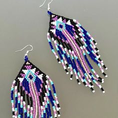 two pairs of beaded earrings on a table