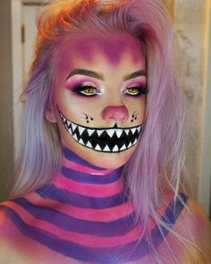 a woman with pink hair and makeup is dressed as a monster face paint on her body