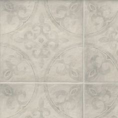 a white tile wall with an ornate design on it