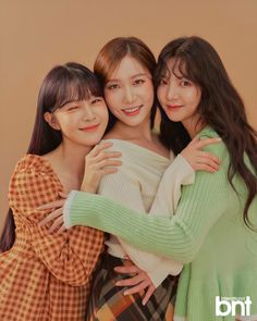 three young women hugging each other and smiling