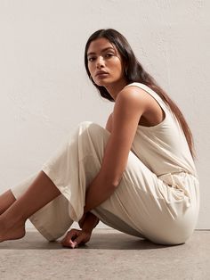 a woman is sitting on the floor with her legs crossed and looking off to the side