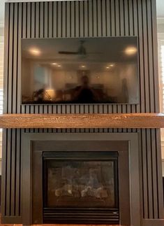 a living room with a fire place and a tv above the fireplace in front of it