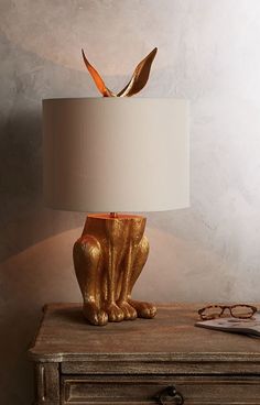 a lamp that is sitting on top of a table next to a pair of glasses