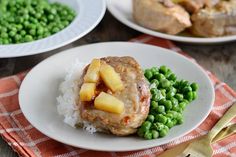 two plates with meat, potatoes and peas on them