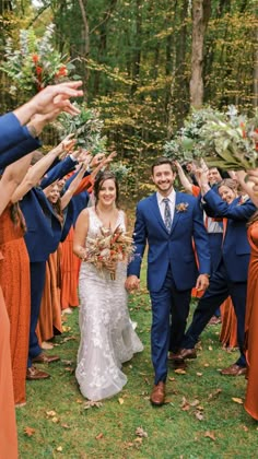 the bride and groom are walking through their wedding party