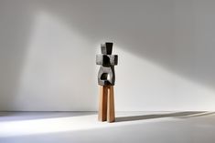 an abstract sculpture stands in the middle of a white room with light coming through it