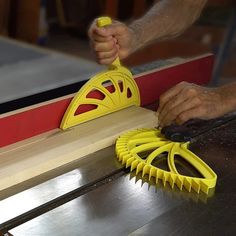 a person using a pair of yellow scissors to cut wood planks on a workbench