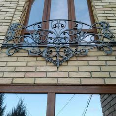 an iron window grill on the side of a brick building