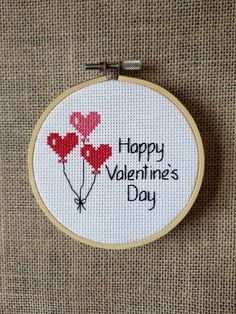 a cross stitch valentine's day card with three red balloons