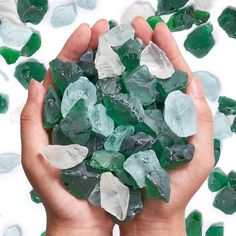 a person holding green and white crystals in their hands