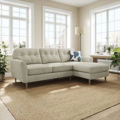 a living room with large windows and a sectional couch