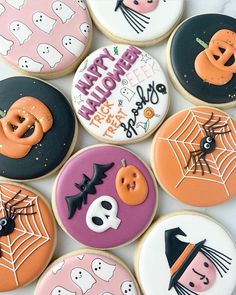 halloween decorated cookies arranged on top of each other in various shapes and colors, including black, orange, pink, and white