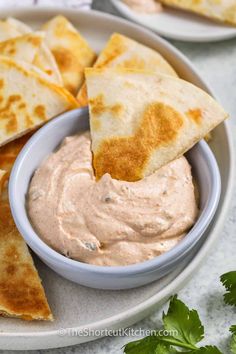 tortilla chips and dip in a bowl on a plate