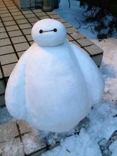 a large white stuffed animal sitting on top of snow covered ground