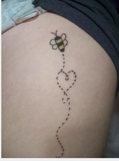 a tattoo on the back of a woman's thigh with a bee flying through it