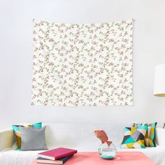 a living room with a white couch and colorful pillows on the table next to it