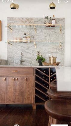 a kitchen with marble counter tops and wooden cabinets, along with wine racks on the wall