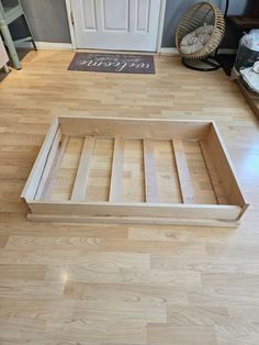 a wooden bed frame sitting on top of a hard wood floor next to a door