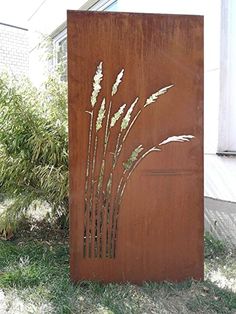 a tall metal sculpture sitting on top of a grass covered field