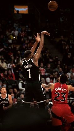 two men playing basketball in front of an audience