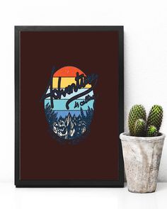 a cactus sits next to a framed poster