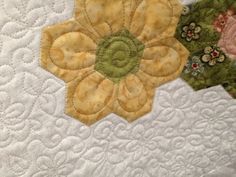 two quilts with flowers on them sitting next to each other