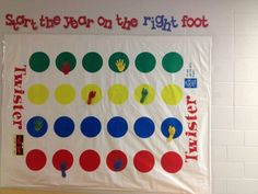 a bulletin board with different colored circles and numbers on it in front of a white brick wall