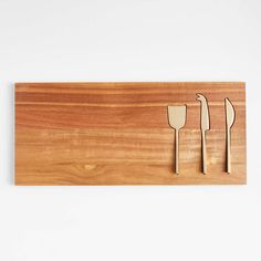 three wooden utensils on a cutting board