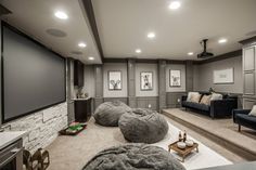 this is an image of a home theater with couches and chairs in the room