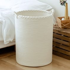 a large white basket sitting on top of a wooden floor