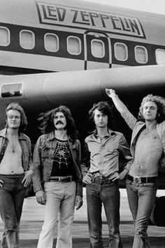 four men standing in front of an airplane