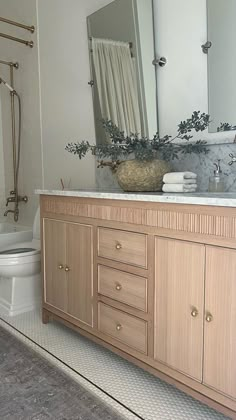 a bathroom with a sink, toilet and mirror in it's center piece is shown