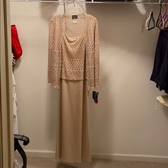 a woman's dress hanging on a clothes rack in a closet with shoes and bras