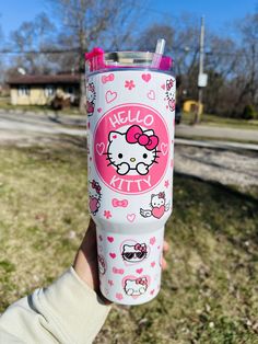 the hello kitty tumbler cup is in someone's hand