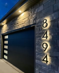 a modern house with an illuminated number on the front door and side entrance to it