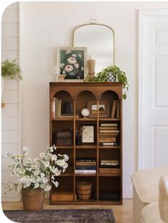 a living room with a book shelf and flowers