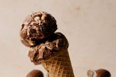 two scoops of ice cream are stacked on top of each other in an ice cream cone